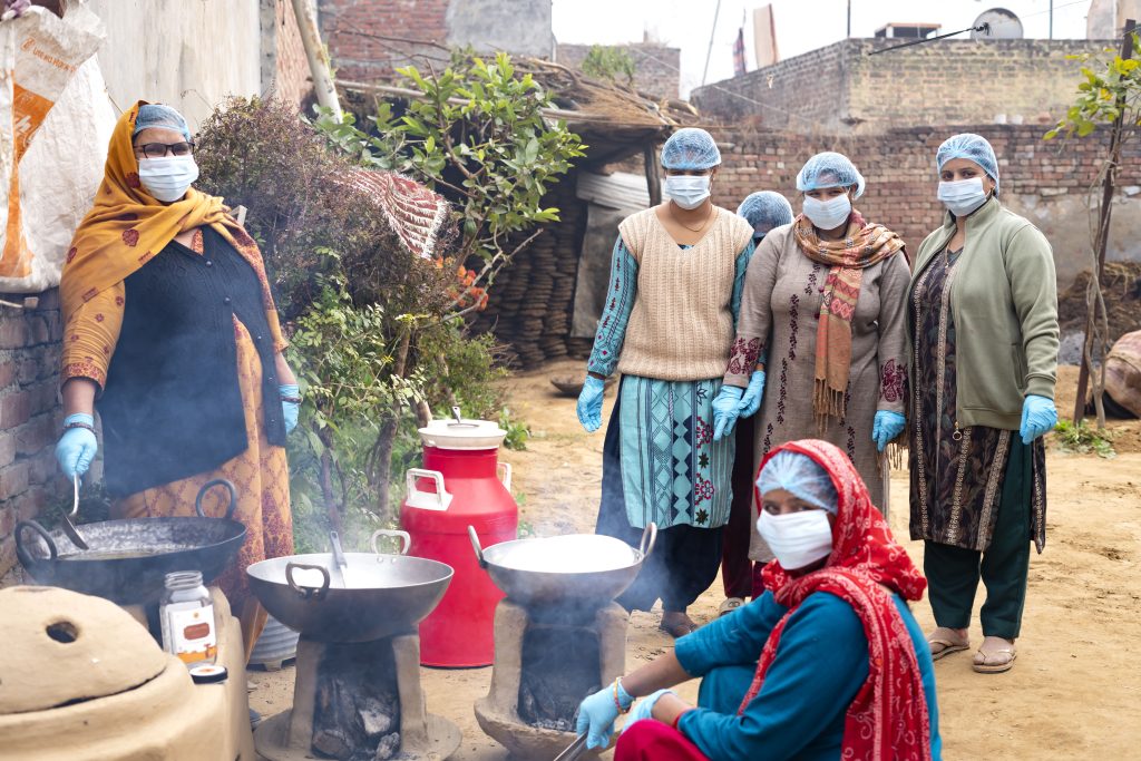 Women artisans preparing traditional Swadamya ghee using slow cooking methods in a rural, hygienic setup